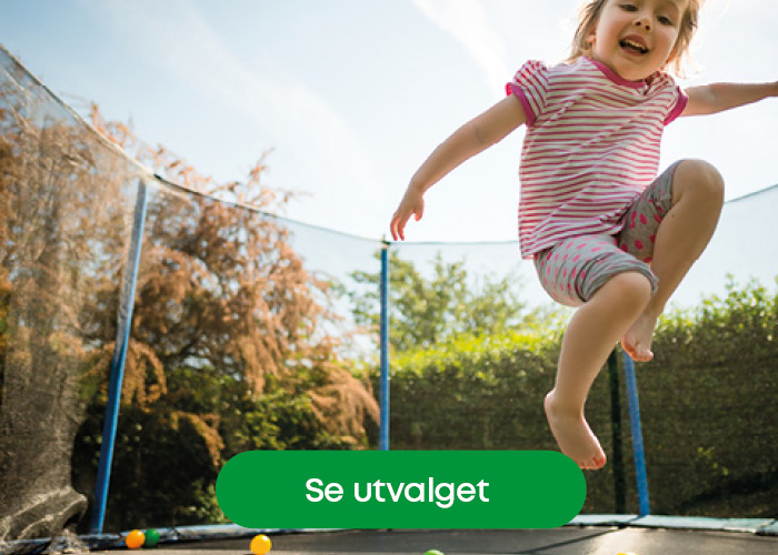 Liten gutt som hopper på trampoline ute i hagen – populær vårlek som gir bevegelse og moro.