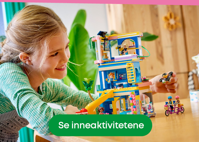 Jente som bygger LEGO ved bordet – kreativ inneaktivitet for barn på rolige vårdager.
